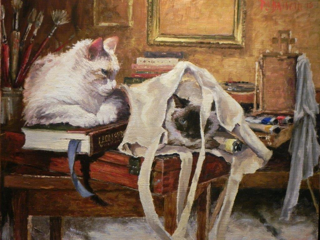 "oil painting of two cats on a table surrounded by art supplies. One cat is laying on a book and the other is peeking out of a canvas bag"